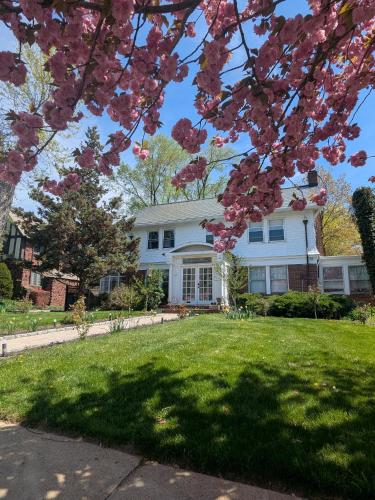 a white house with a tree with pink flowers at GuestHouse in Elizabeth