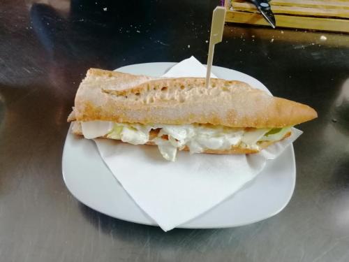 un panino su un piatto bianco con uno stuzzicadenti dentro di Hostal Bar Restaurante Villa Cerollera a Cerollera