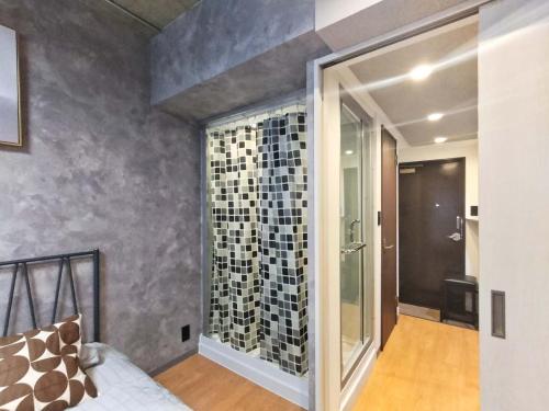 a bedroom with a glass shower in a room at PA Shinjuku St a-9mins -Higashishinjuku subway-5mins-新宿-步行伊势丹8分-MAX4p in Tokyo