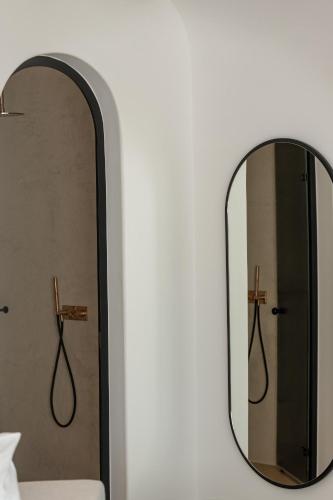 a mirror on a wall next to a bed at Muse οf Mykonos Luxury Suites in Mýkonos City