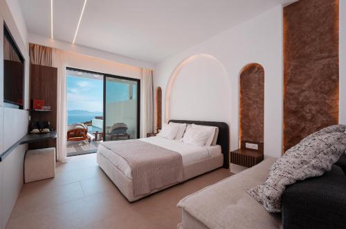a bedroom with a bed and a view of the ocean at Muse οf Mykonos Luxury Suites in Mýkonos City