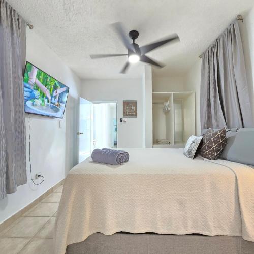 a bedroom with a bed with a ceiling fan at Casa Colora in Naguabo