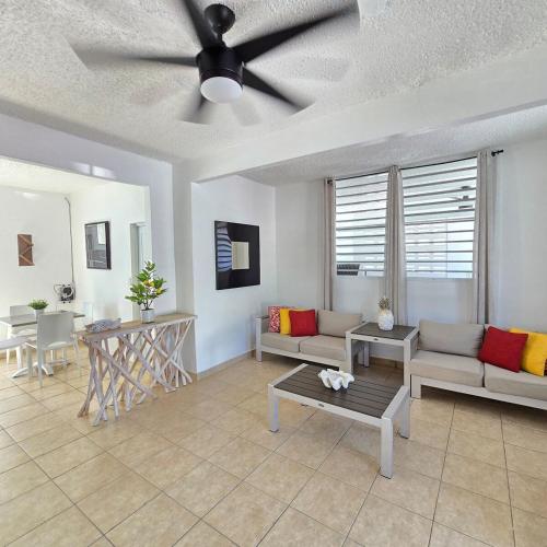 a living room with couches and a ceiling fan at Casa Colora in Naguabo