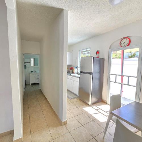 a kitchen with a stainless steel refrigerator and a table at Casa Colora in Naguabo