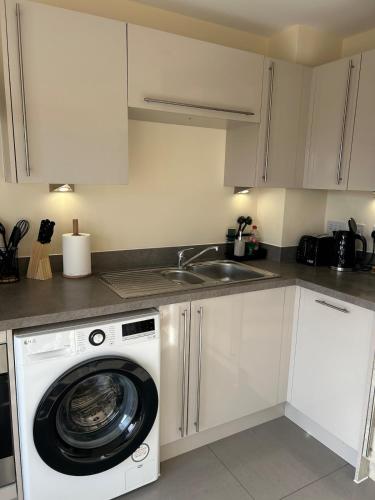 a kitchen with a washing machine and a sink at Trent View - New House in Branston, Staffordshire in Branston