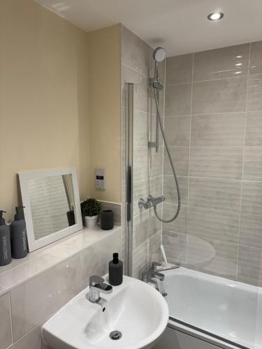 a bathroom with a sink and a shower and a tub at Trent View - New House in Branston, Staffordshire in Branston