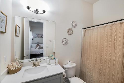 a bathroom with a sink and a toilet and a mirror at Stylish 3BR Home in CLT, Close to Downtown, Airport, WFH & Parking & Family Friendly & Business Ready in Charlotte