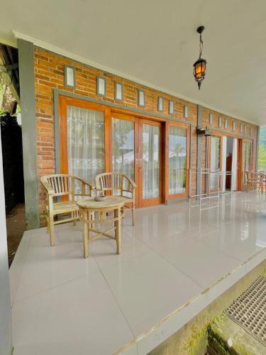 a living room with a table and chairs and windows at Sekumpul Accommodation in Singaraja
