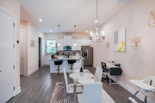 a kitchen and living room with white cabinets and a table at Stylish 3BR Home in CLT, Close to Downtown, Airport, WFH & Parking & Family Friendly & Business Ready in Charlotte