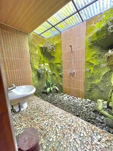 a bathroom with a shower and a toilet and a sink at Sekumpul Accommodation in Singaraja