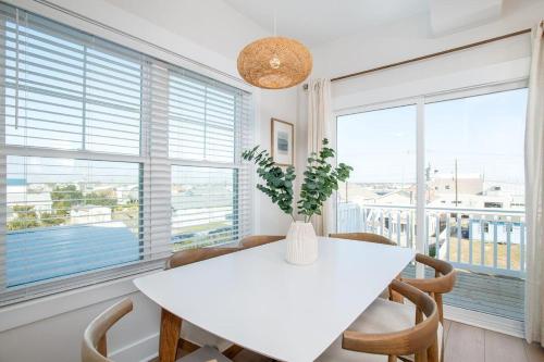a white dining room with a white table and chairs at SALTY DALTY & THREE BUOYS townhouse in Atlantic Beach