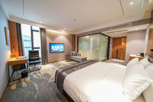 a hotel room with a large bed and a desk at Kelly Jinyue Hotel in Chengdu