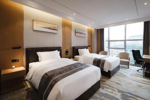 a hotel room with two beds in a room at Kelly Jinyue Hotel in Chengdu
