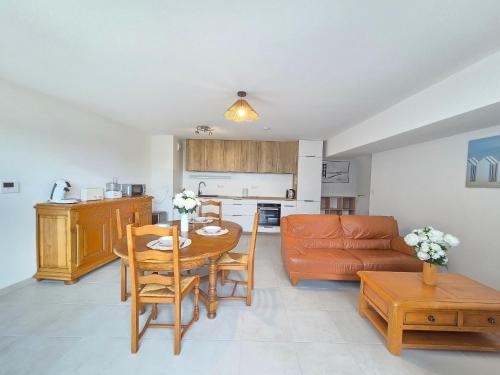 une cuisine et un salon avec une table et un canapé dans l'établissement Appartement moderne avec terrasse proche mer et centre, Wi-Fi inclus à Saint-Brevin - FR-1-364-182, à Saint-Brévin-les-Pins