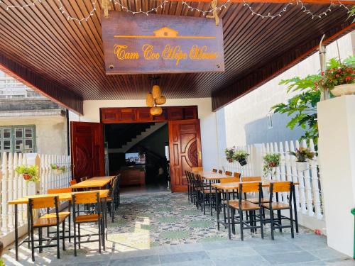 a restaurant with wooden tables and chairs and a sign at Tam Coc Hope House in Ninh Binh