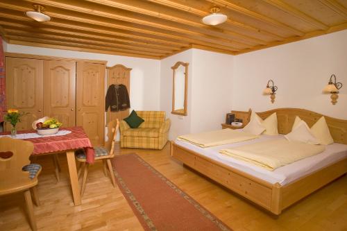 - une chambre avec un lit, une table et une chaise dans l'établissement Pension Breitenlohner, à Reit im Winkl