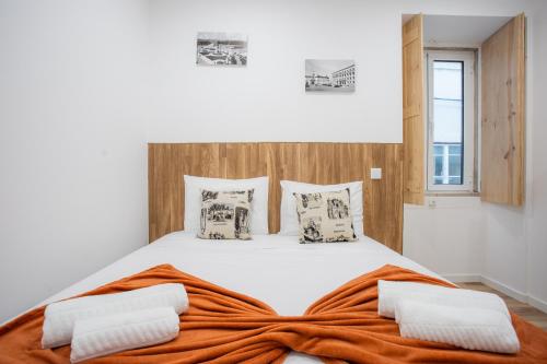 a bedroom with a large bed with an orange blanket at COIMBRA CITY CHARM in Coimbra