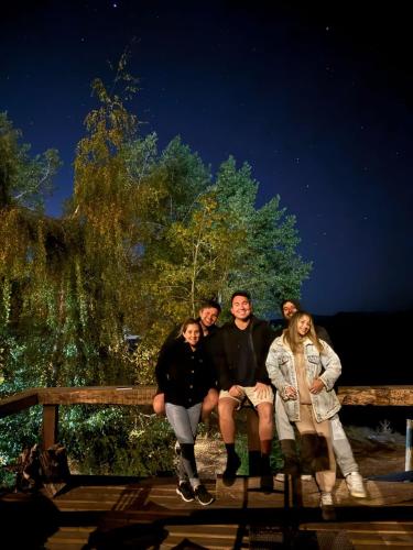 a group of people sitting on a wooden fence at Hostal Boutique CUMBRES in Farellones