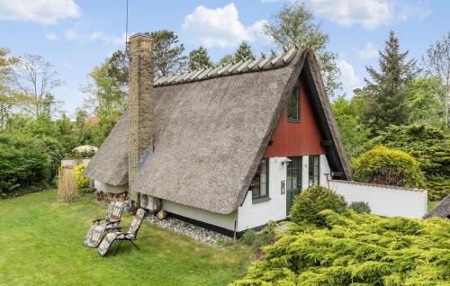 a house with a thatched roof and two chairs at Pet Friendly Home In Sydals With Wifi in Sønderby