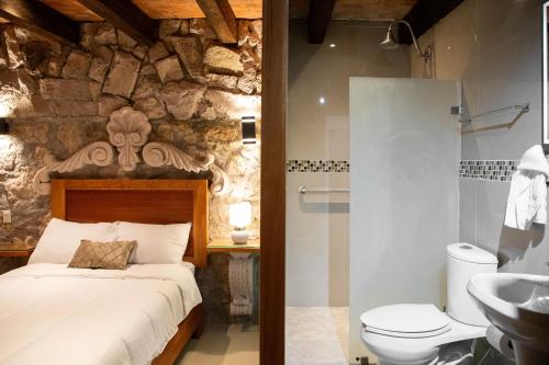 a bathroom with a bed and a toilet and a sink at Casa Serdán, Suites & Events in Morelia