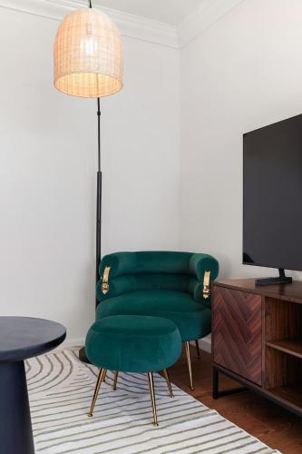 a living room with a green chair and a tv at Relaxing 2-Bedroom Oasis in Pacifica in Pacifica
