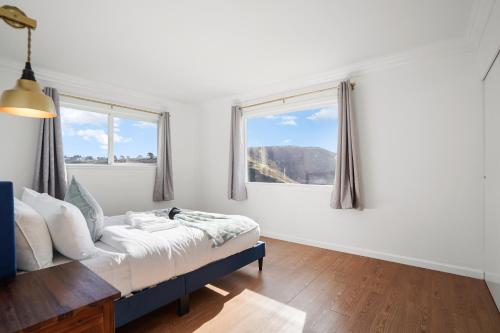 a bedroom with a bed and two windows at Relaxing 2-Bedroom Oasis in Pacifica in Pacifica
