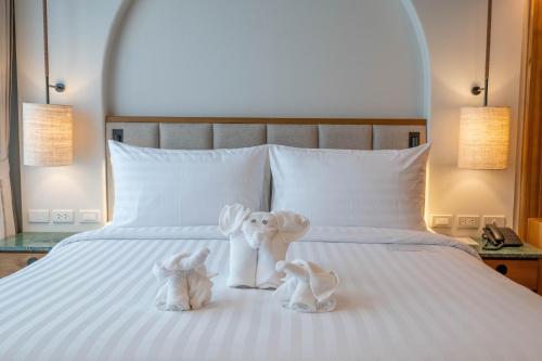 two stuffed animals sitting on top of a bed at Phi Phi at Pier in Phi Phi Don