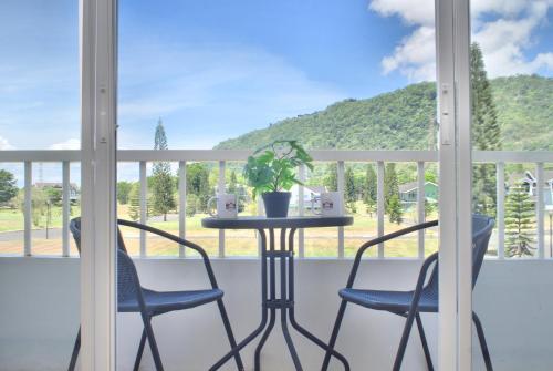 a balcony with two chairs and a table with a plant at Cozy Crib Saratoga in Tagaytay Midlands with Breakfast in Tagaytay