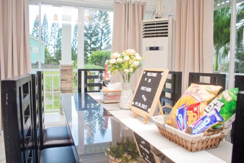 a dining room with a glass table and flowers at Cozy Crib Saratoga in Tagaytay Midlands with Breakfast in Tagaytay