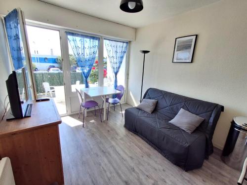 un salon avec un canapé et une table dans l'établissement Studio proche plage à Châtelaillon avec terrasse et parking - Animaux admis - FR-1-706-9, à Châtelaillon-Plage