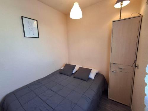 une petite chambre avec un lit avec deux oreillers dans l'établissement Studio proche plage à Châtelaillon avec terrasse et parking - Animaux admis - FR-1-706-9, à Châtelaillon-Plage