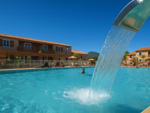 un homme dans une piscine avec une fontaine dans l'établissement Pavillon climatisé, proche plages et village, terrasse, parking, animaux admis - Argelès-sur-Mer - FR-1-732-4, à Argelès-sur-Mer