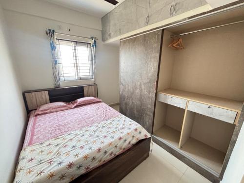a small bedroom with a bed and a closet at Cozy 1 BHK near Kadugodi metro in Bengaluru