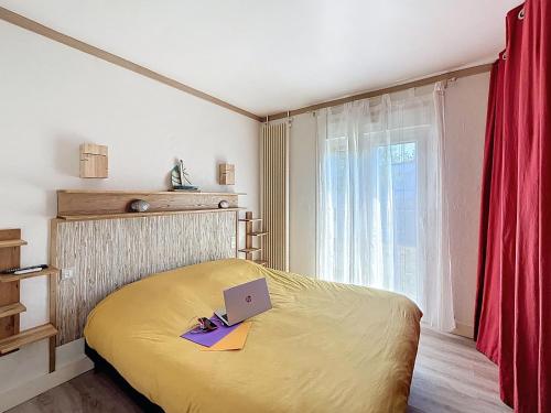 une chambre avec un lit avec un ordinateur portable dessus dans l'établissement Maison de vacances à 350m de la plage avec jardin, véranda et Wi-Fi gratuit - FR-1-361-525, à Saint-Pair-sur-Mer