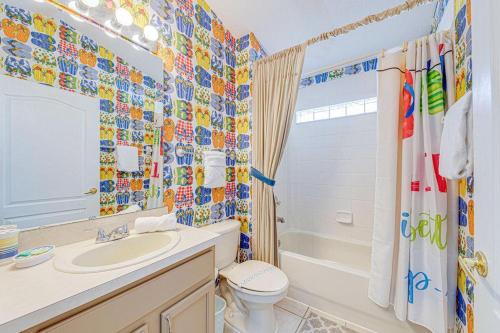 Un baño con inodoro, lavabo y bañera. en Pool Therapy - New Pool Home, en Orlando