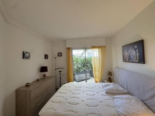a bedroom with a white bed and a window at Appartement avec grande terrasse et garage à Cavalaire-sur-Mer - FR-1-100-355 in Cavalaire-sur-Mer