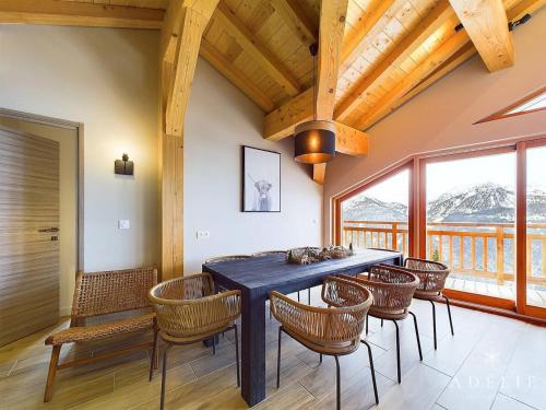 une salle à manger avec une table et des chaises bleues dans l'établissement Appartement de luxe 8 pers. avec cheminée, parking, proche pistes et commerces - FR-1-398-683, à Montvalezan