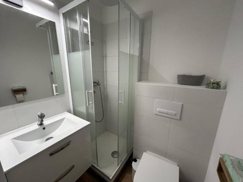 une salle de bain blanche avec une douche et un lavabo dans l'établissement Studio rénové avec grande terrasse proche plage - FR-1-388-239, à Argelès-sur-Mer