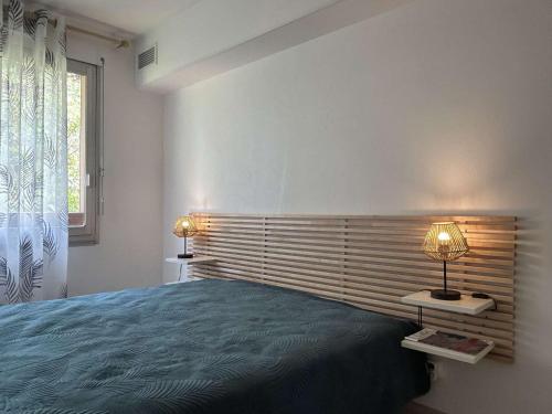une chambre avec un lit et deux lampes et une fenêtre dans l'établissement Appartement 3 pièces, parking, climatisation, Banyuls-sur-Mer - FR-1-225C-168, à Banyuls-sur-Mer