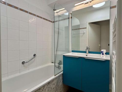 La salle de bains est pourvue d'une armoire bleue, d'une baignoire et d'un lavabo. dans l'établissement Appartement 2 pièces à Argelès-sur-Mer avec piscine - FR-1-225-831, à Argelès-sur-Mer