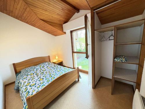 a small bedroom with a bed and a window at Maison calme proche plage et commerces - FR-1-831-13 in Biscarrosse