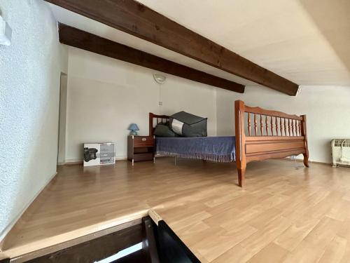 une chambre avec un lit et un parquet dans l'établissement Pavillon avec mezzanine, terrasse ensoleillée, WIFI et parking à Argelès-sur-Mer - FR-1-388-240, à Argelès-sur-Mer