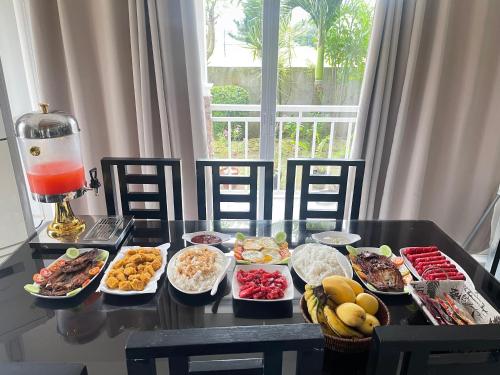 a table with many different dishes of food on it at Cozy Crib Saratoga in Tagaytay Midlands with Breakfast in Tagaytay