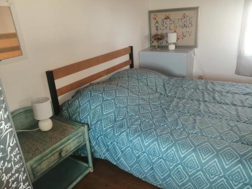 une chambre avec un lit avec une couette bleue dans l'établissement Maison à Noirmoutier - Proche Plage - Parking - FR-1-823-98, à Noirmoutier-en-l'lle
