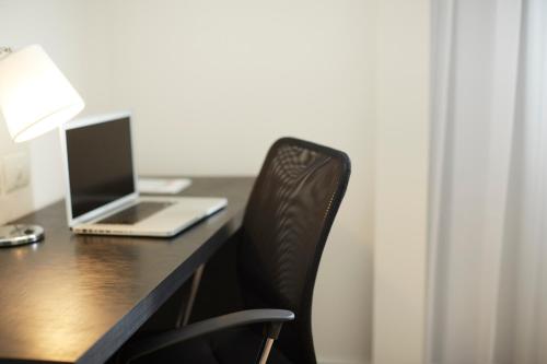 a laptop computer sitting on top of a wooden desk at Tulip Inn Itaguai in Itaguaí