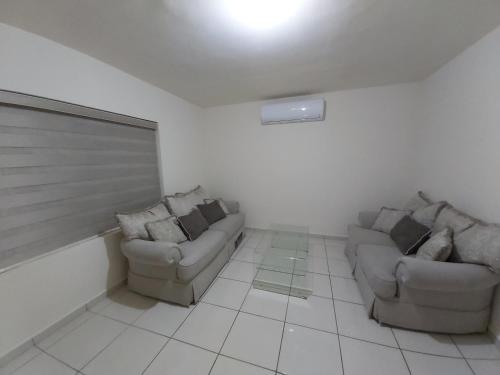a living room with two couches in a room at Casa con alberca compartida Netflix Disney Amazon TV in Hermosillo