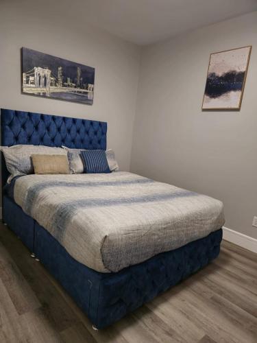 a bed in a bedroom with a blue headboard at 2 bedroom basement-All Incl in Fort McMurray