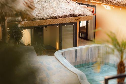 a pool in front of a building with a thatch roof at Hanna Retreat - Venuestay in Sa Pa