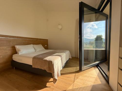 a bedroom with a bed and a large window at Exclusive Villa Perla & swimming pool in Bovezzo