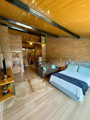 a bedroom with a bed and a brick wall at Pousada Refúgio das Águas Quarto 3 in Chapecó